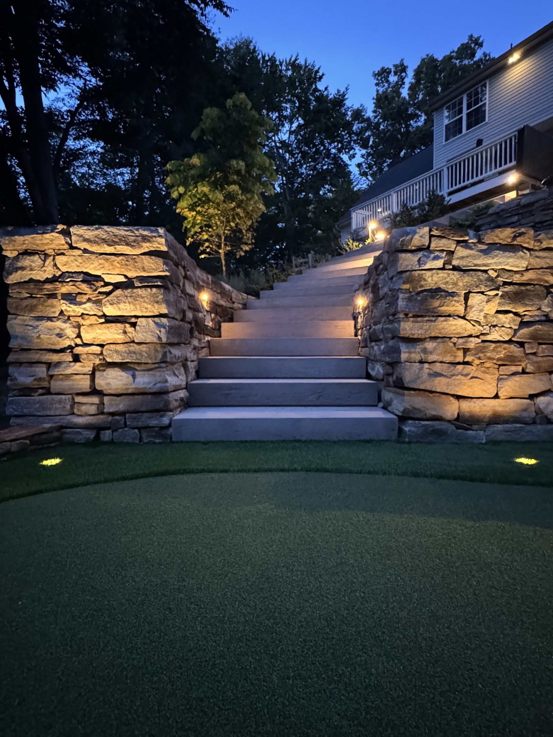 Techo Bloc Borealis Steps, Putting Green, Natural Stone Wall, and Brilliance Versa Beam Lights